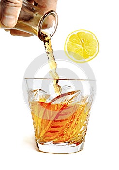whiff of alcohol pours with splashes into the glass with Ã¢â¬Å½lobule of lemon. . photo